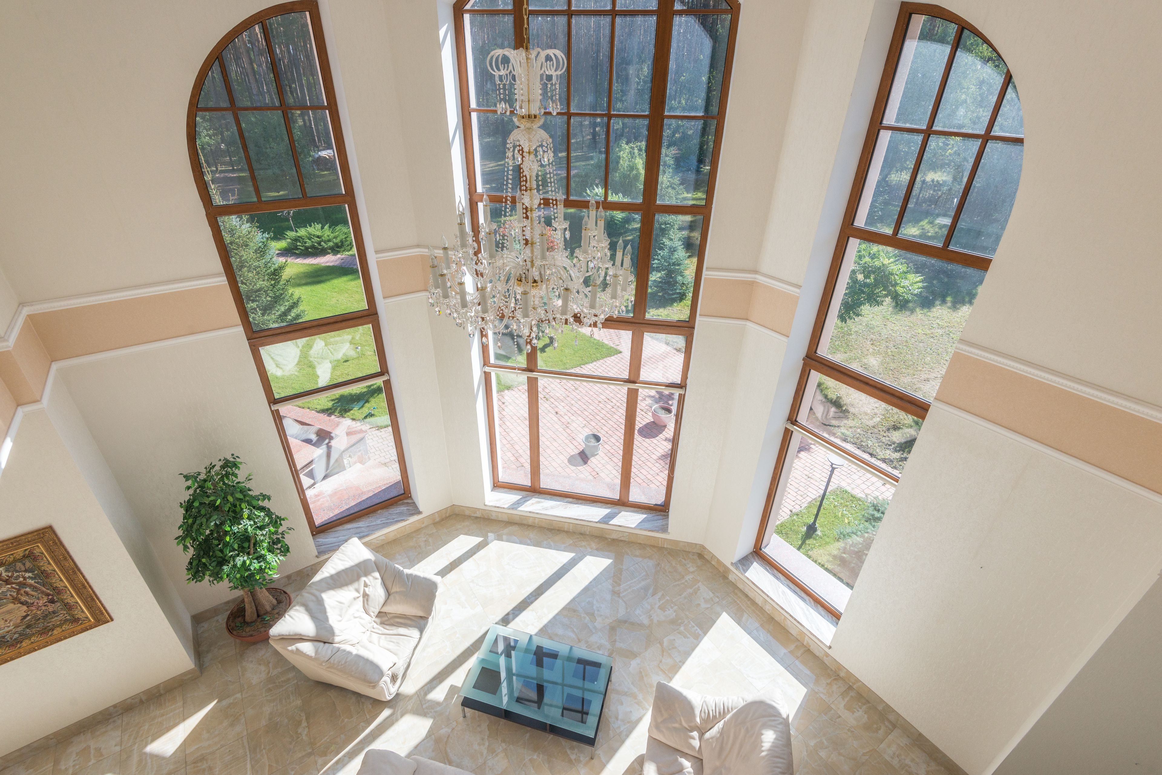 Bright luxury living room with floor-to-ceiling windows and a grand chandelier